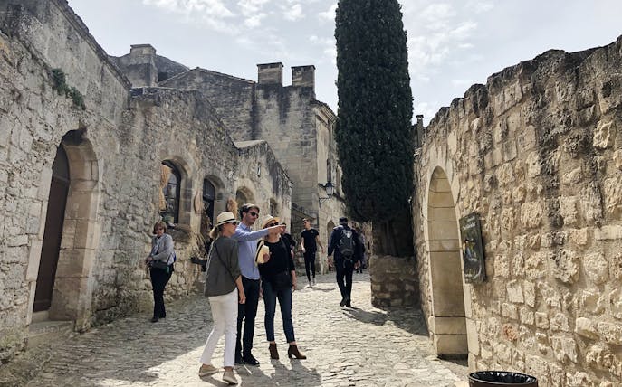 Visitors exploring historic stone streets in Les Baux De Provence, Provence, France.