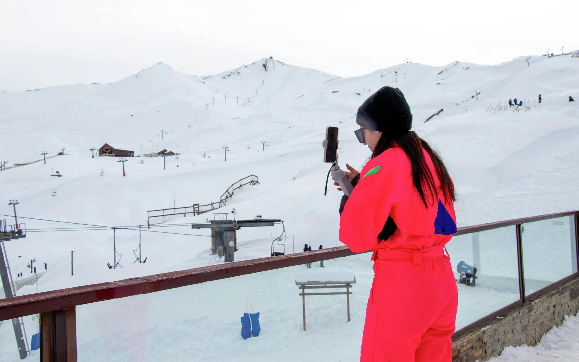 Tourist filming at Valle Nevado ski resort in the Andes Mountains, Chile.