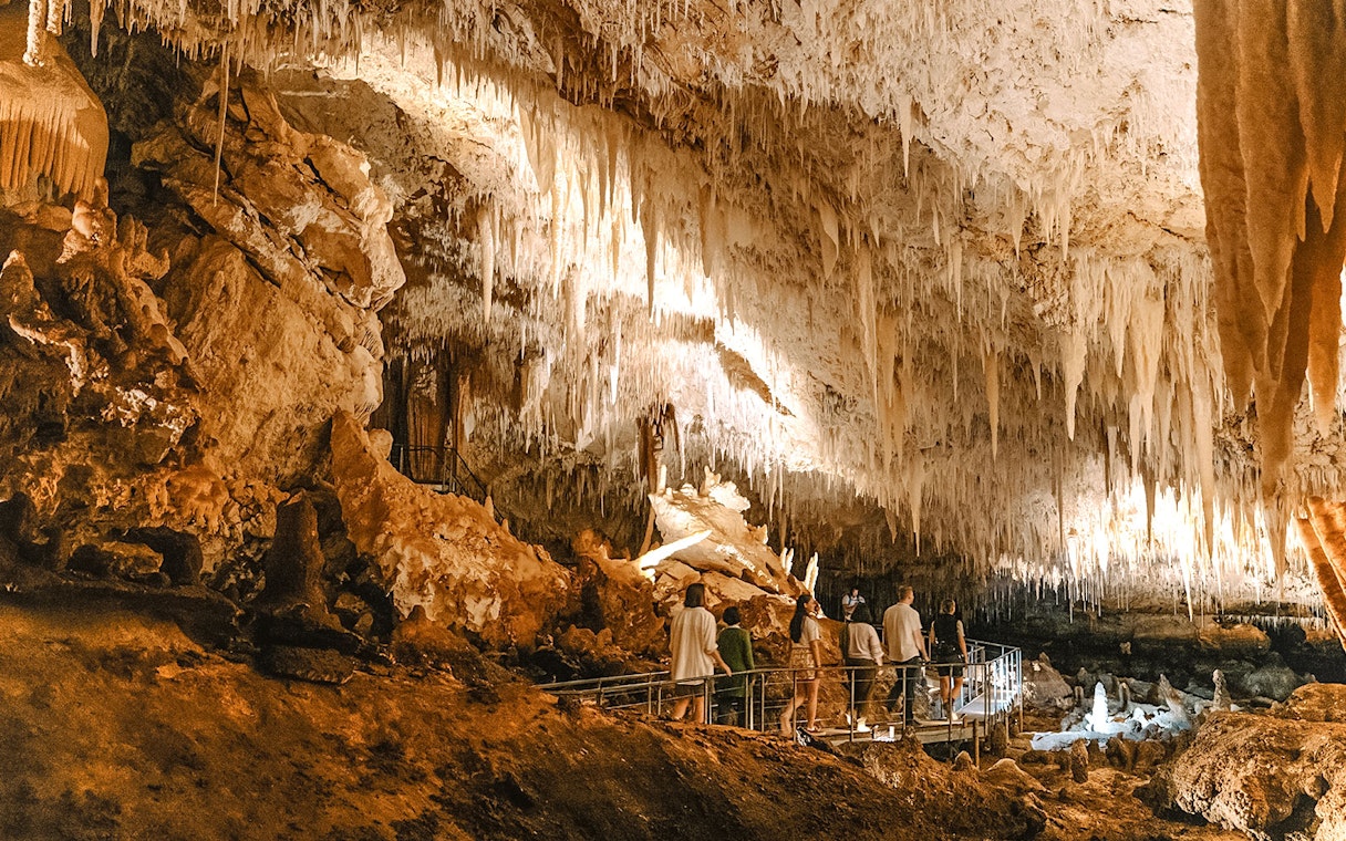 Visitors exploring stalactites in Jewel Cave, Margaret River guided tour.