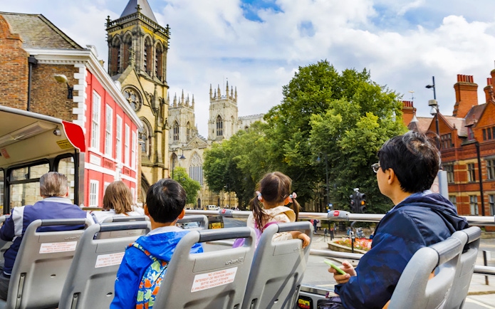 Open-top bus tour passing York Minster on York Hop-On-Hop-Off Tour.