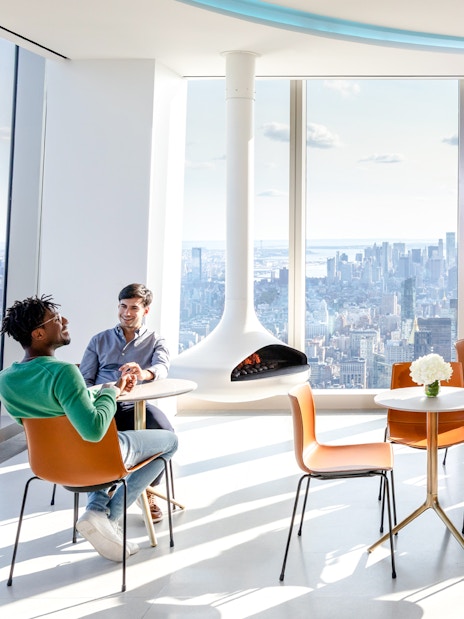Visitors enjoying the view from SUMMIT One Vanderbilt observation deck with the Empire State Building visible.