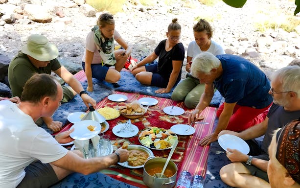 People enjoying a traditional Moroccan meal in Agafay Desert, Marrakech.