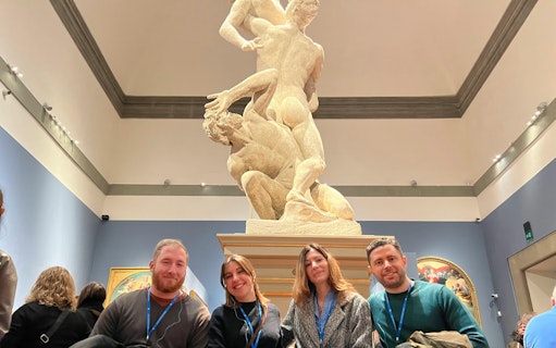 Visitors in front of a classical sculpture at a museum.