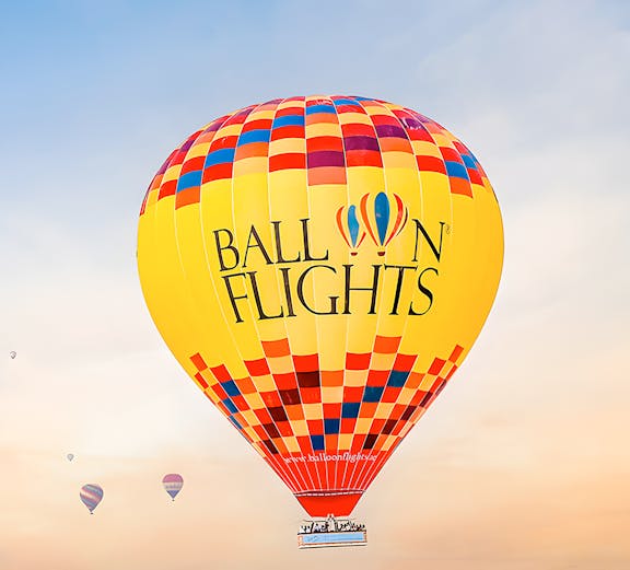 Hot air balloon over desert landscape, limited time deal.