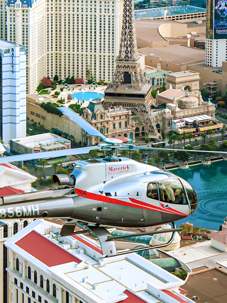 Maverick Helicopter flying over the Las Vegas Strip with city landmarks below.