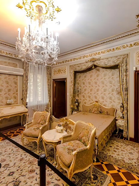 Interior of Ceaușescu Mansion bedroom with ornate decor and chandelier, Bucharest.