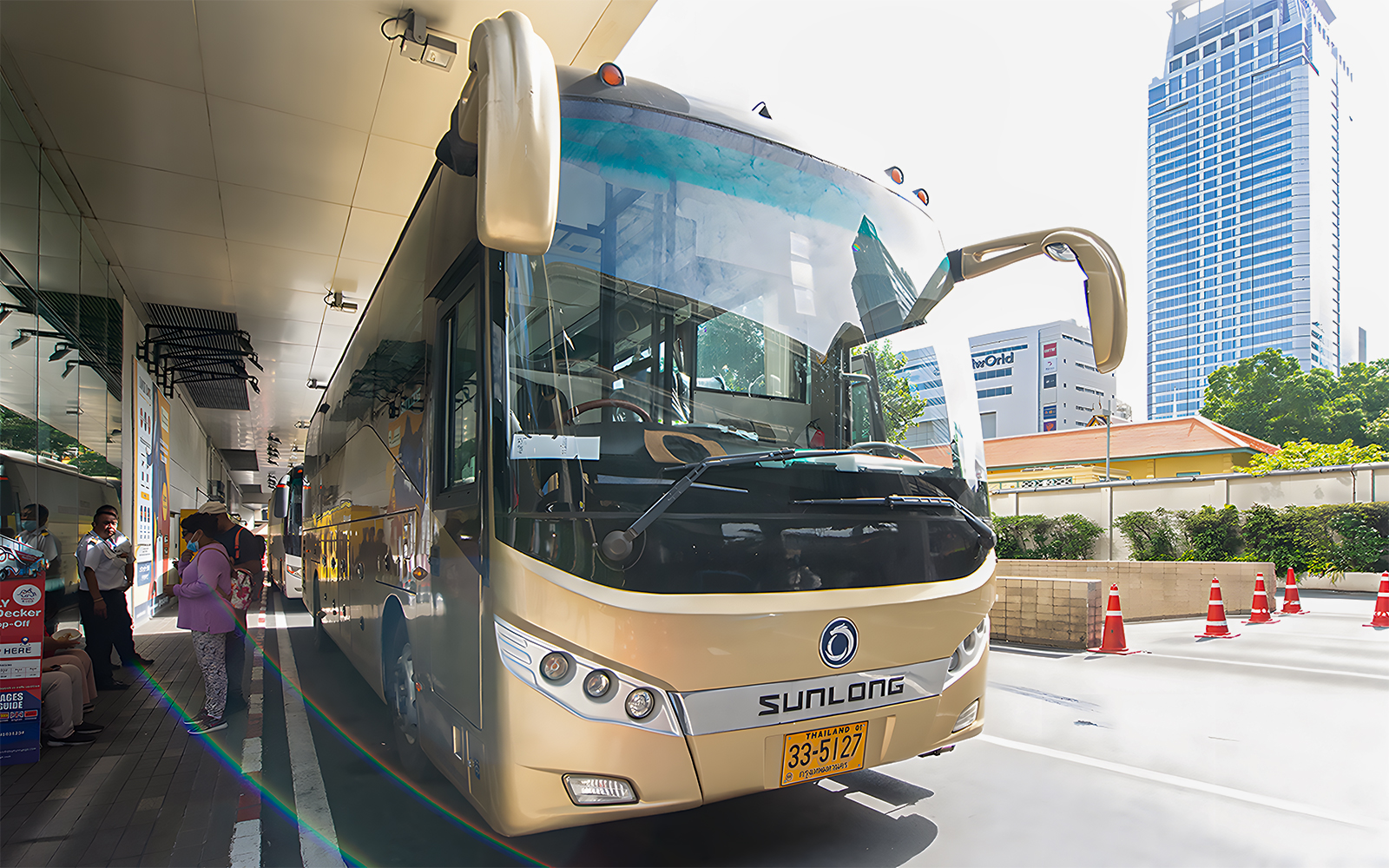 Tour bus parked at a station, ready for the Damnoen Saduak Floating Market & Maeklong Railway Market tour.
