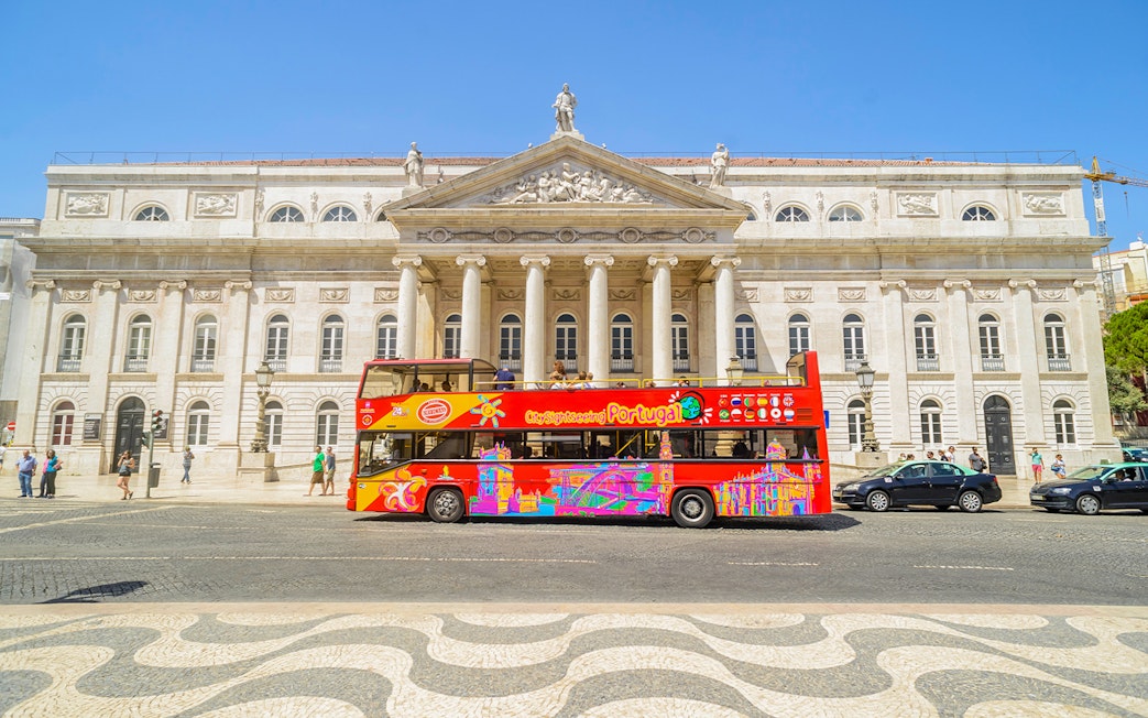Hop-On Hop-Off Lisbon bus in front of Lisbon's National Theatre.
