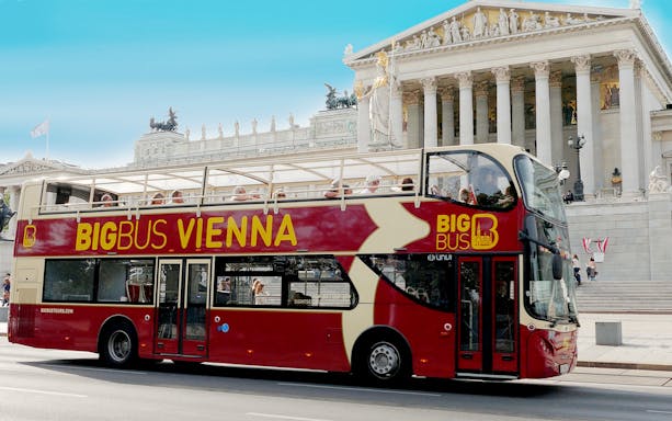 Open-top tour bus in front of the Austrian Parliament Building in Vienna.