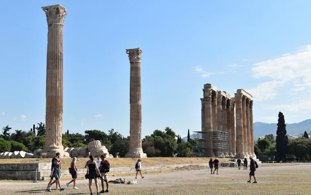 Temple of Olympian Zeus ruins with tourists walking, Athens.