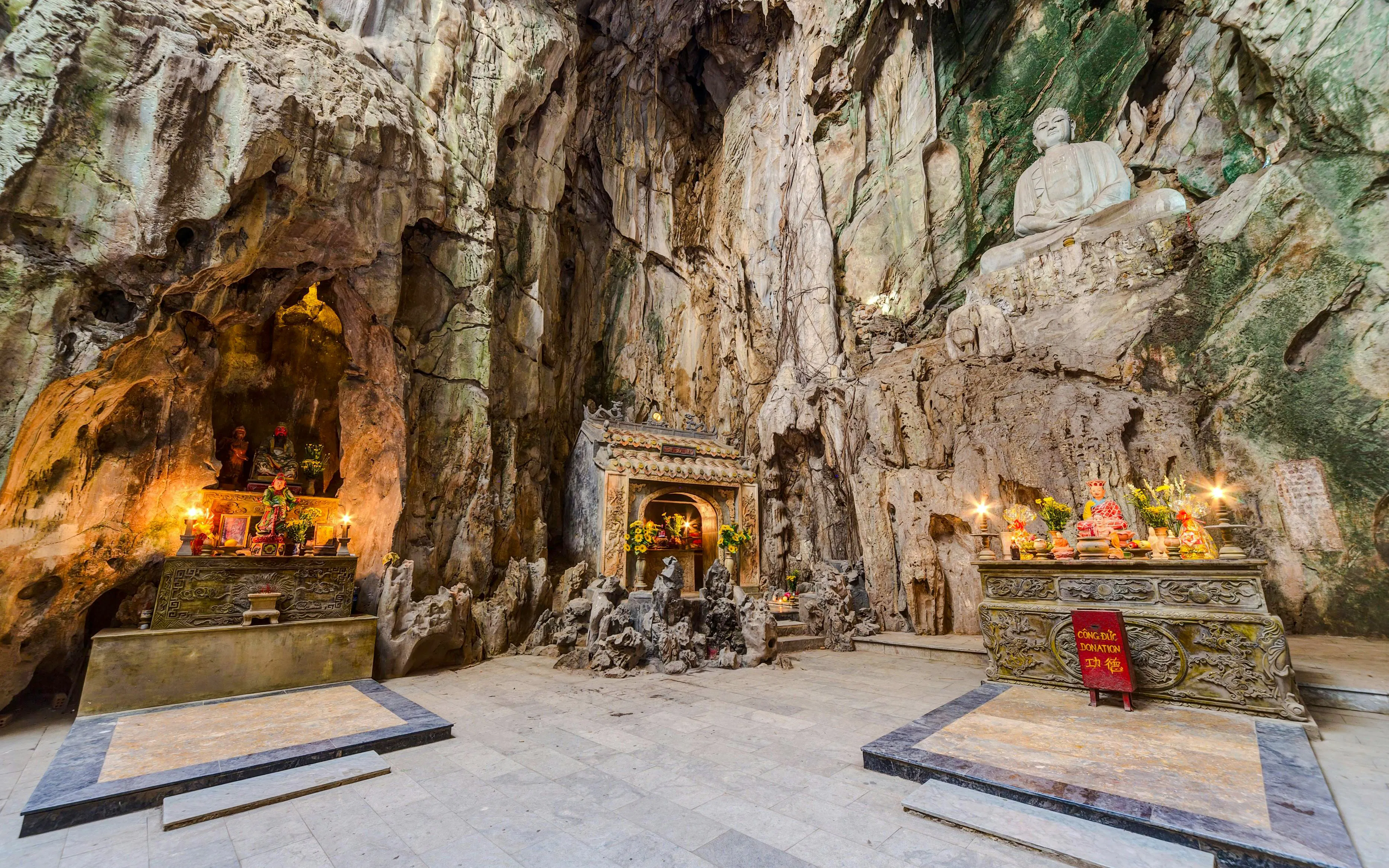 Shrine inside Huyền Không Cave with altars and statues, Marble Mountains, Đà Nẵng.