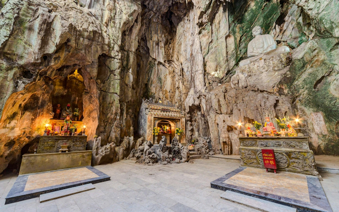 Shrine inside Huyền Không Cave with altars and statues, Marble Mountains, Đà Nẵng.