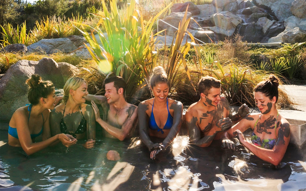 Group enjoying Hell's Gate mud bath in a natural setting.