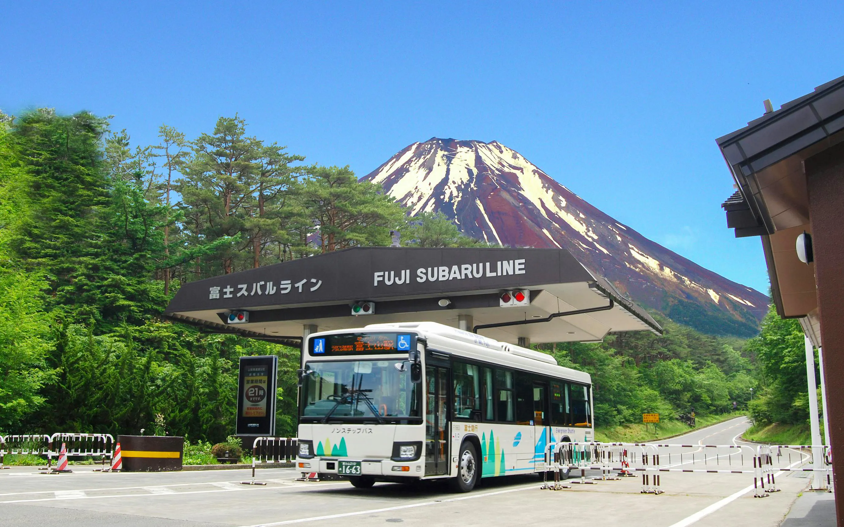 Bus at Fuji Subaru Line gate with Mt. Fuji in the background, Japan.