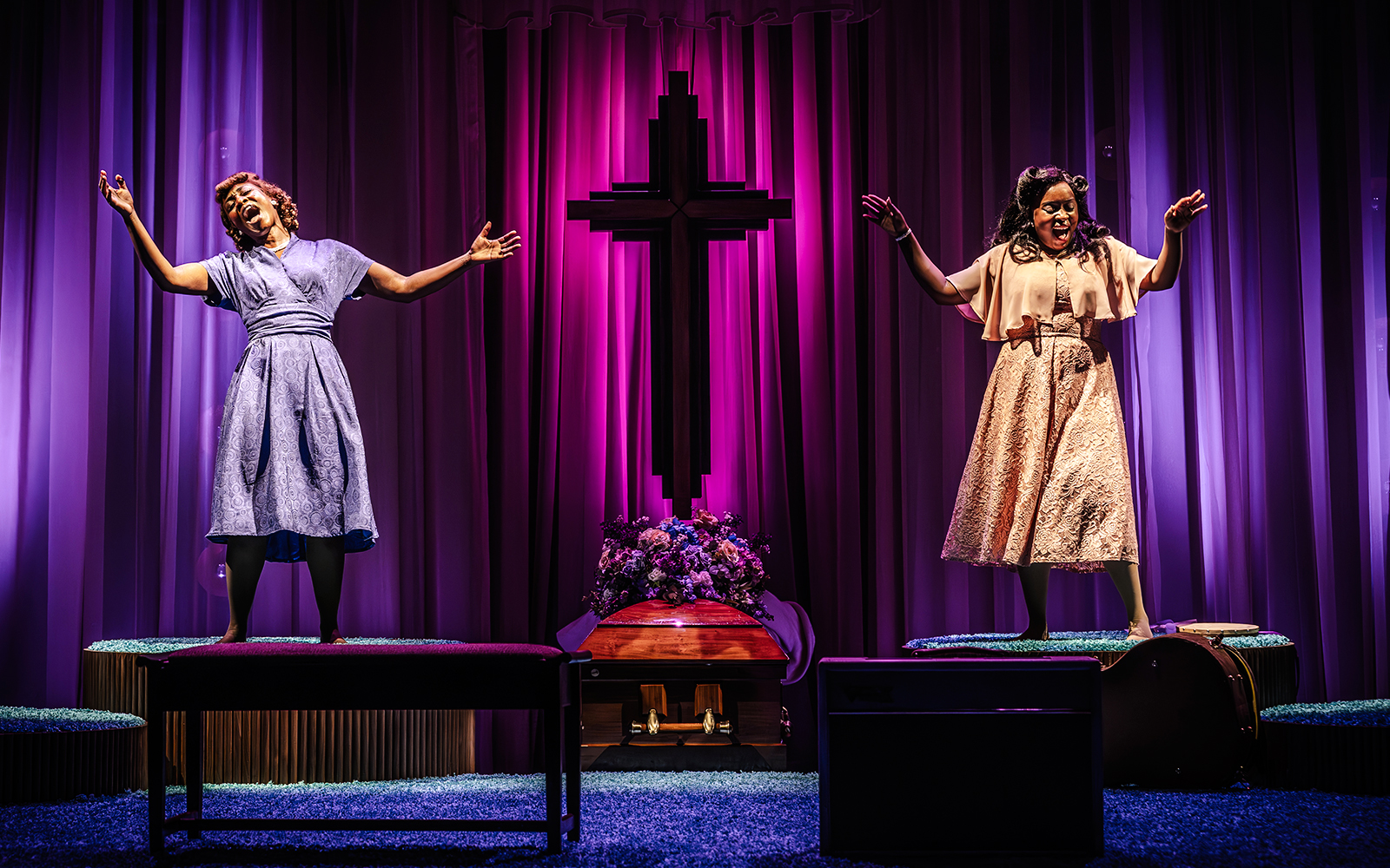 Performers singing on stage in Marie & Rosetta production with purple backdrop and cross.