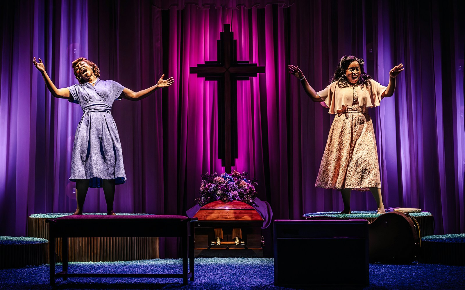 Performers singing on stage in Marie & Rosetta production with purple backdrop and cross.