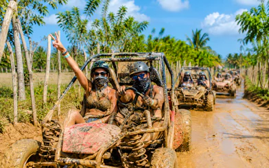 Tourists driving buggies on muddy trail in Bayahibe, Punta Cana adventure.