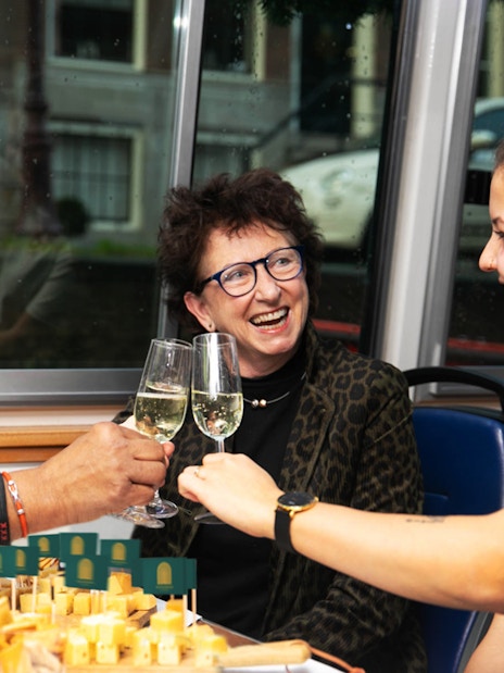 Guests toasting with wine during Amsterdam Light Festival cheese tasting tour.