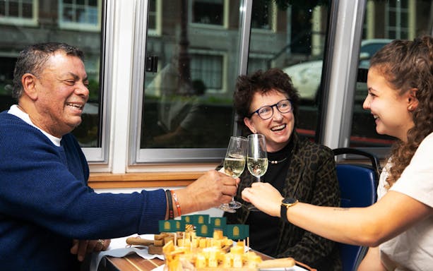 Guests toasting with wine during Amsterdam Light Festival cheese tasting tour.