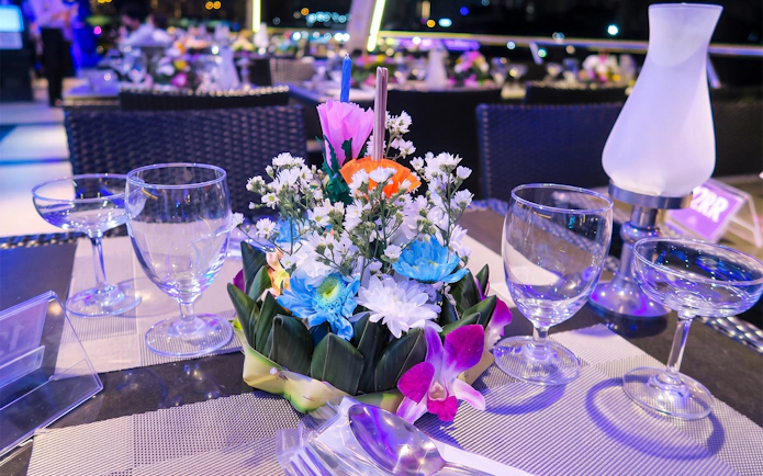Floral arrangement on table during Chao Phraya Princess Loy Krathong festival dinner cruise.