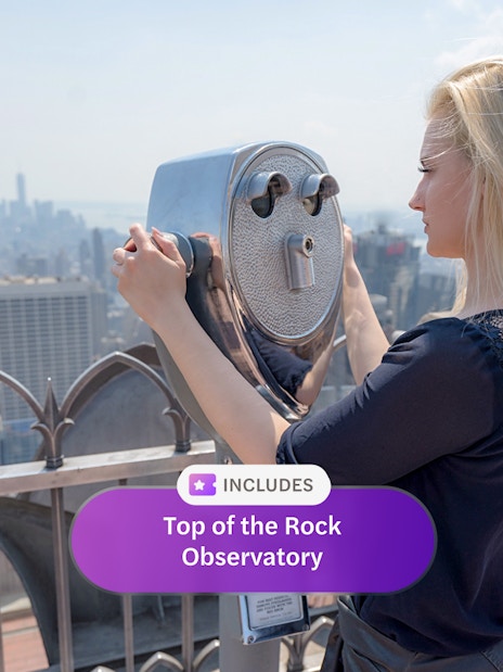 Person using binoculars at Top of the Rock Observatory, New York City skyline in view.