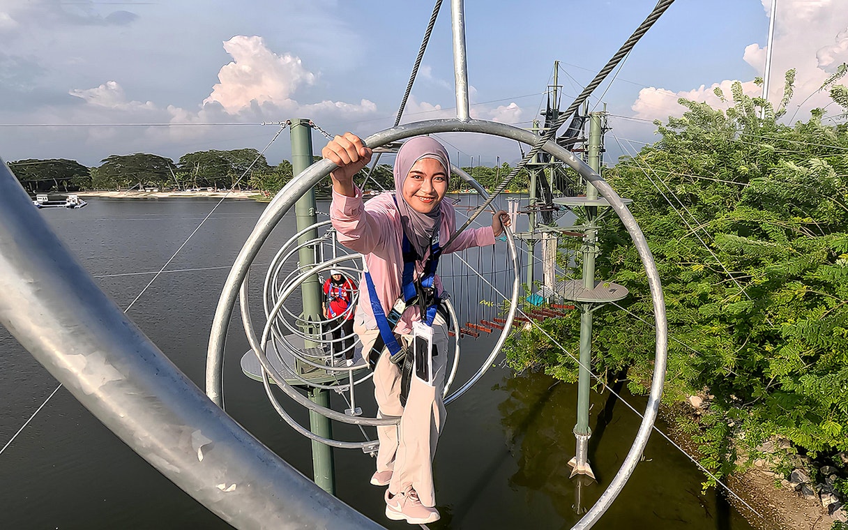 Person navigating a rope obstacle course at ESCAPE Ipoh Theme Park, Malaysia.