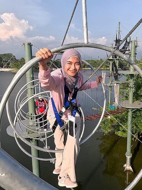 Person navigating a rope obstacle course at ESCAPE Ipoh Theme Park, Malaysia.