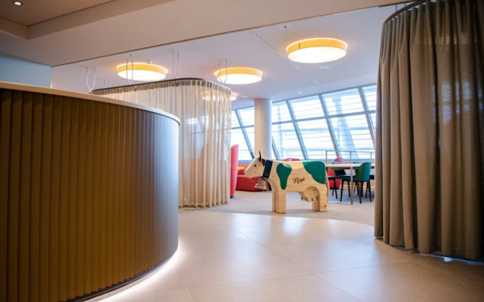 Seating area with wooden cow sculpture at Marhaba Lounge, Zurich Airport Airside Centre.