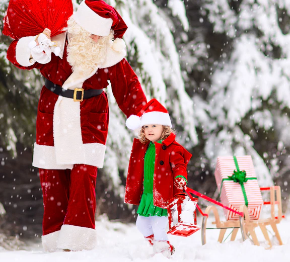 Santa and child with gifts in snowy forest.