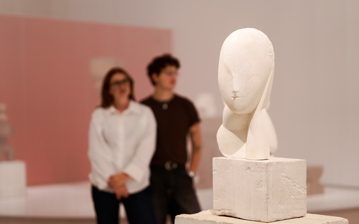 Sculpture exhibit inside the H’ART Museum with visitors observing.