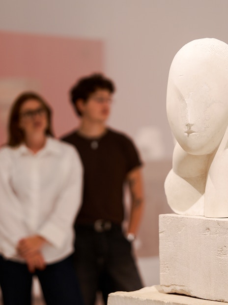 Sculpture exhibit inside the H’ART Museum with visitors observing.