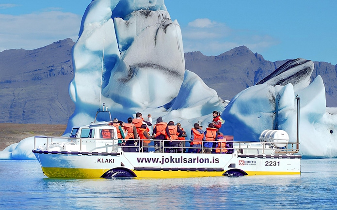 Boat tour at Jökulsárlón Glacier Lagoon with icebergs in the background, South Coast Iceland.