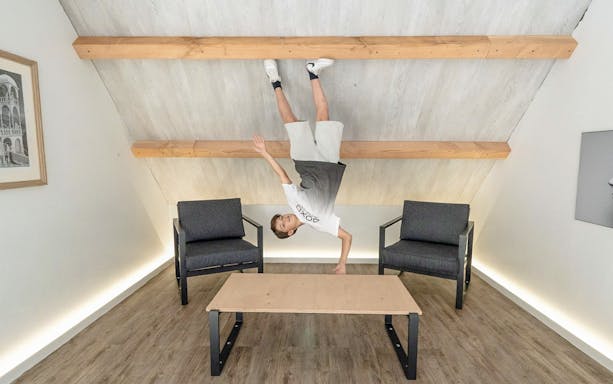Guest experiencing an upside-down room at the Museum of Illusions Amsterdam.