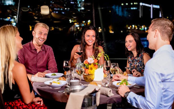 Guests enjoying dinner on a Seine River sightseeing cruise.