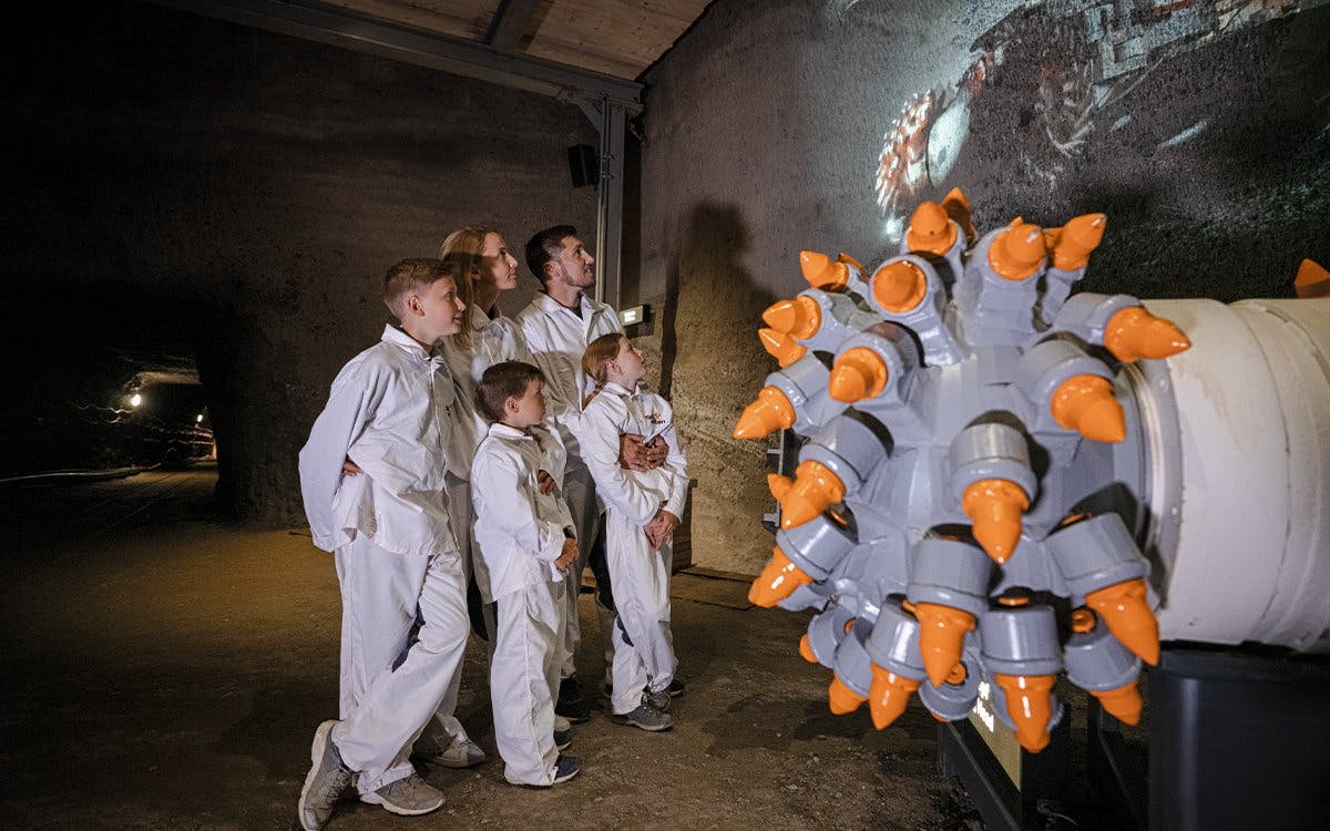 Visitors in protective suits exploring Hallein salt mines, Salzburg.