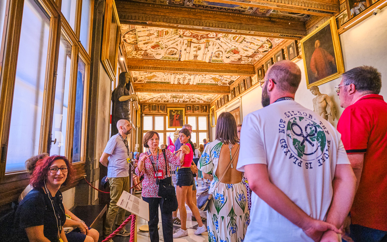 Tour group exploring the Vasari Corridor with art and sculptures, Florence, Italy.