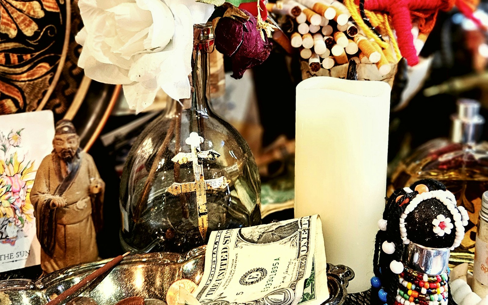 Voodoo artefacts with cross, candle, and figurine on New Orleans Haunted Ghost, Voodoo & Vampire Tour.