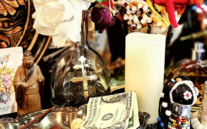 Voodoo artefacts with cross, candle, and figurine on New Orleans Haunted Ghost, Voodoo & Vampire Tour.
