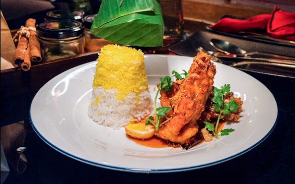 Gourmet dish with saffron rice and glazed chicken on Saffron Luxury Cruise by Banyan Tree.