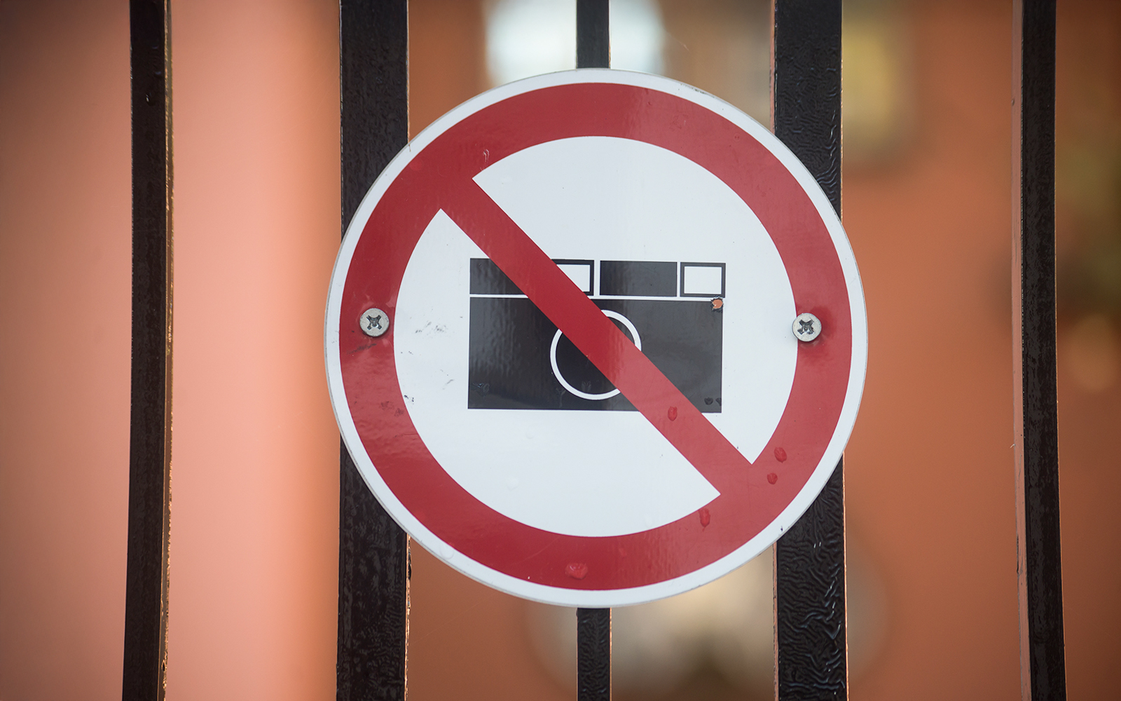 Photography prohibited signboard on a gate in a restricted area.