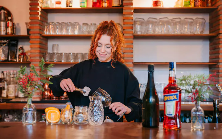 Bartender preparing a cocktail at Tablao Jardines de Zoraya bar.