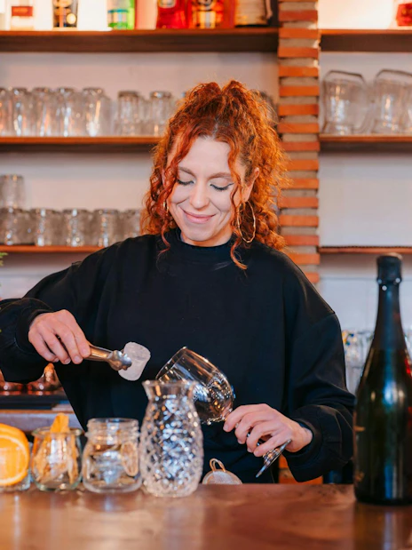 Bartender preparing a cocktail at Tablao Jardines de Zoraya bar.