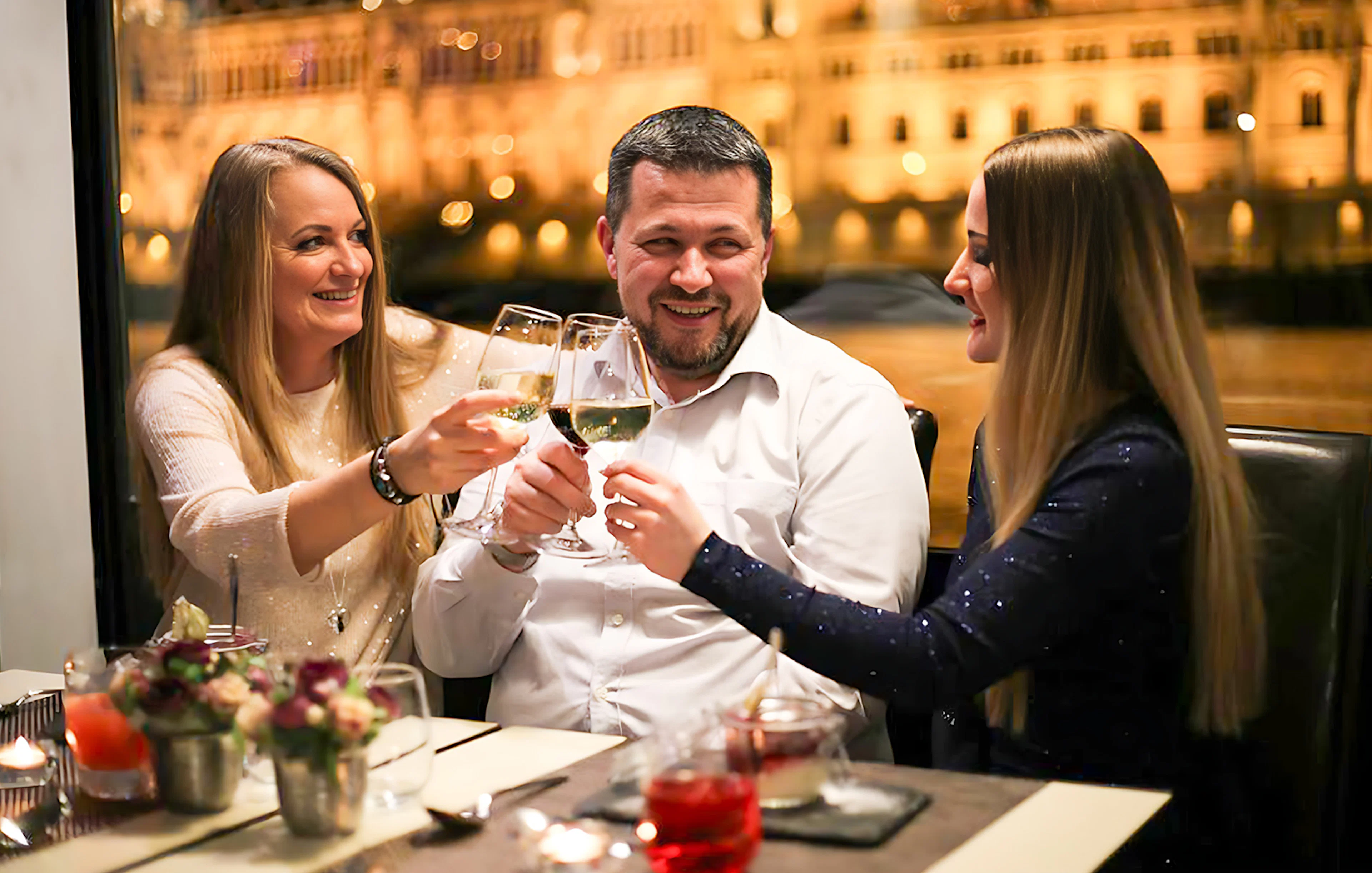 Guests toasting on a Budapest New Year's Eve cruise on the Danube with drinks.