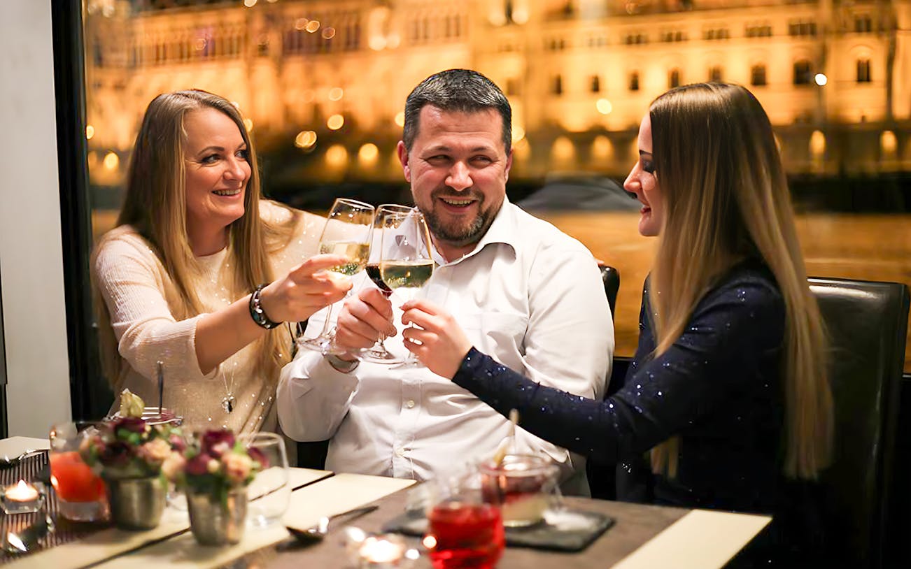 Guests toasting on a Budapest New Year's Eve cruise on the Danube with drinks.