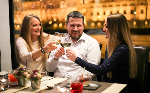Guests toasting on a Budapest New Year's Eve cruise on the Danube with drinks.