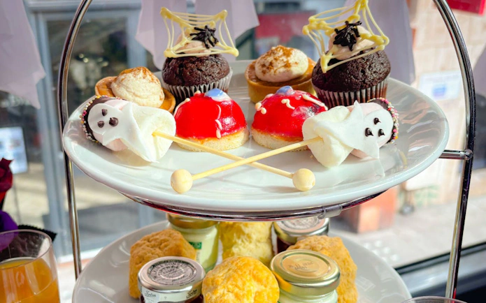 Halloween-themed treats on a London afternoon tea bus tour, featuring cupcakes and ghost-shaped sweets.