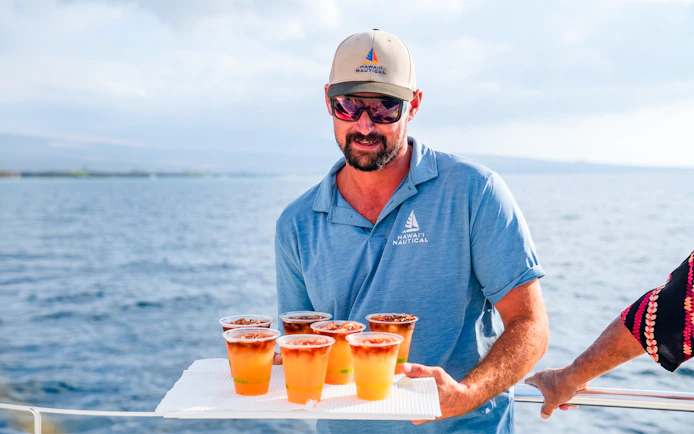 Server offering drinks on Waikiki Deluxe Whale Watch Sail.