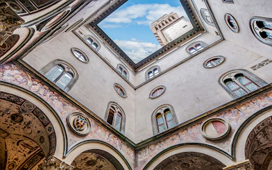 Cloister view with frescoes and tower at Palazzo Vecchio, Florence.