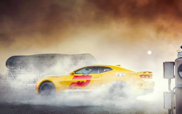 Chevrolet Camaro SS on track at Yas Marina Circuit with smoke in the background.