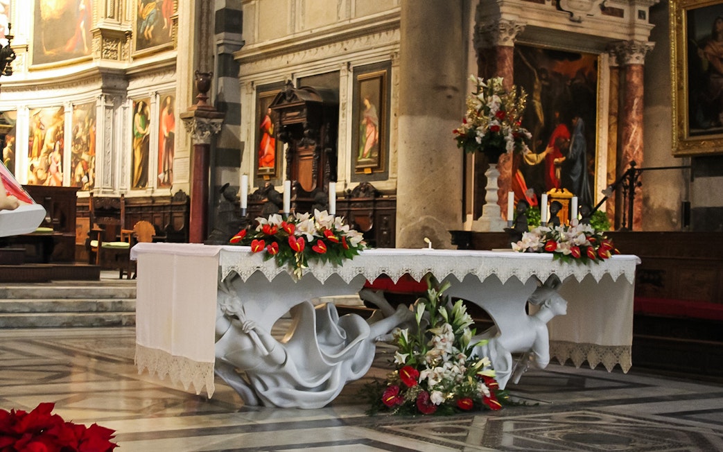 Altar inside Pisa Cathedral with ornate decorations and religious artwork.